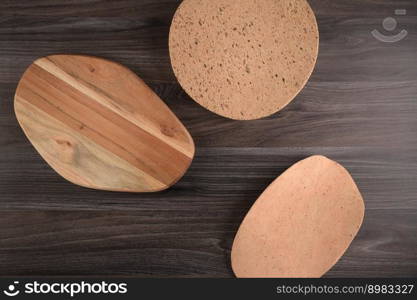 Top view of wooden cutting board on old dark wood countertop.