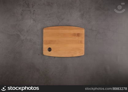 Top view of wooden cutting board on old stone countertop.