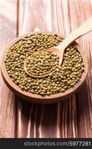 Top view of wooden spoon full of green mung beans texture. Green mung beans