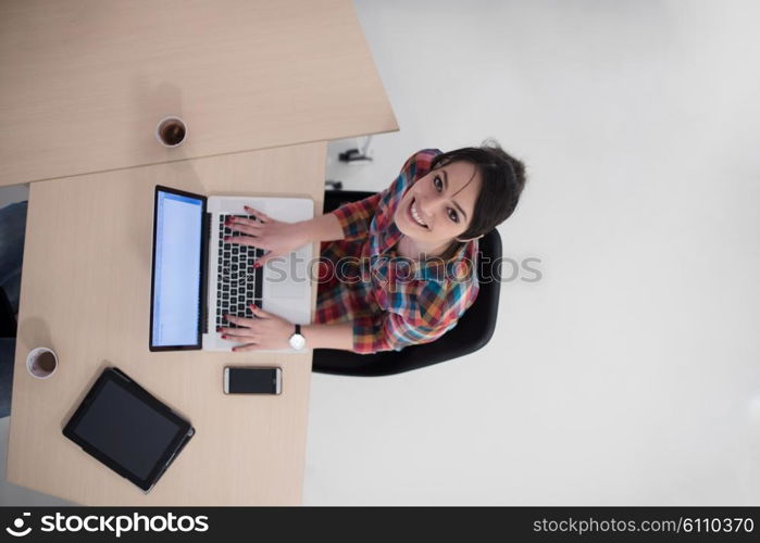 top view of young business woman working on laptop computer in modern bright startup office interior