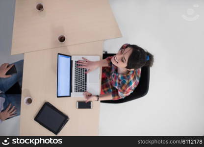 top view of young business woman working on laptop computer in modern bright startup office interior