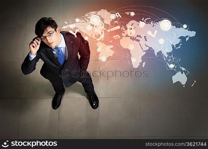 Top view of young businessman making decision against global network back