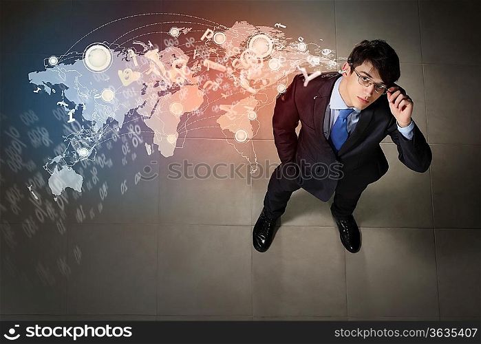 Top view of young businessman making decision against global network back