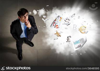 Top view of young businessman making decision currency signs in air