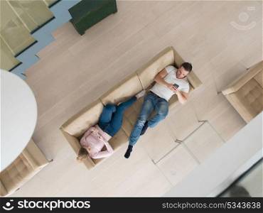top view of Young couple on sofa using a mobile phones