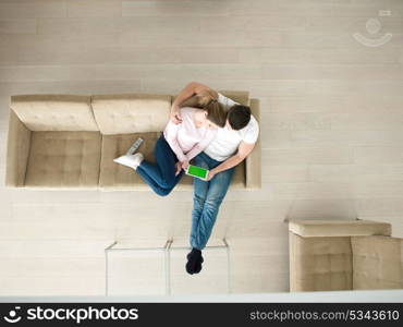 top view of Young couple on sofa using a tablet computer