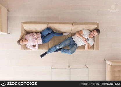 top view of Young couple on the sofa watching television together at home