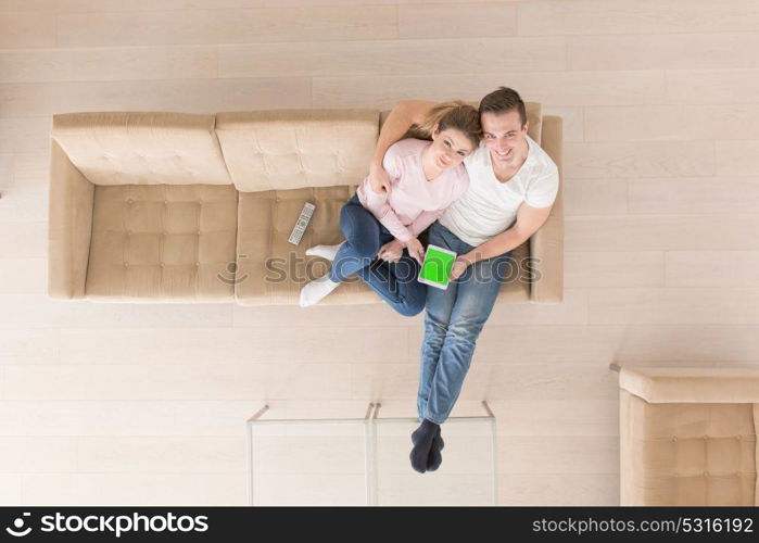 top view of Young couple sitting on a sofa in the luxury living room, using a tablet computer