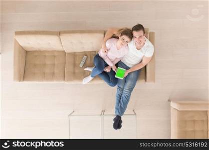 top view of Young couple sitting on a sofa in the luxury living room, using a tablet computer