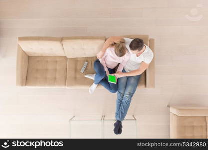 top view of Young couple sitting on a sofa in the luxury living room, using a tablet computer