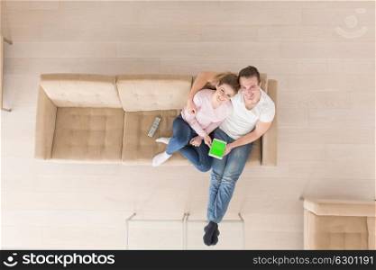 top view of Young couple sitting on a sofa in the luxury living room, using a tablet computer
