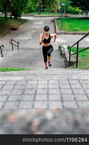 Top view of young female athlete training climbing stairs outdoors. Female athlete climbing stairs outdoors