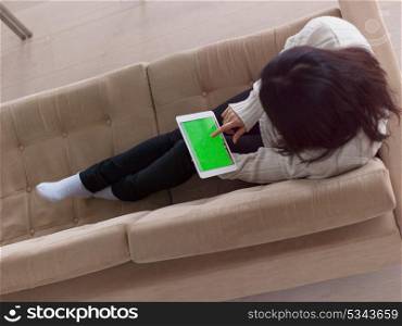 top view of young happy asian woman sitting on sofa using Digital Tablet