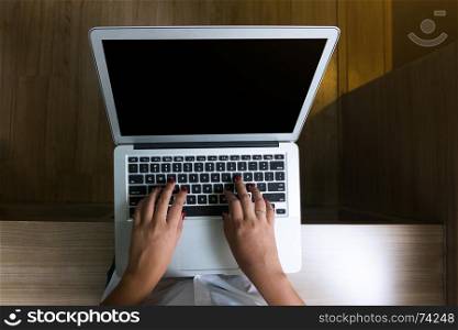 Top view of young woman sitting and using laptop