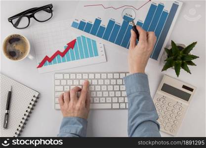 top view office desk with growth chart hands with keyboard. Resolution and high quality beautiful photo. top view office desk with growth chart hands with keyboard. High quality and resolution beautiful photo concept