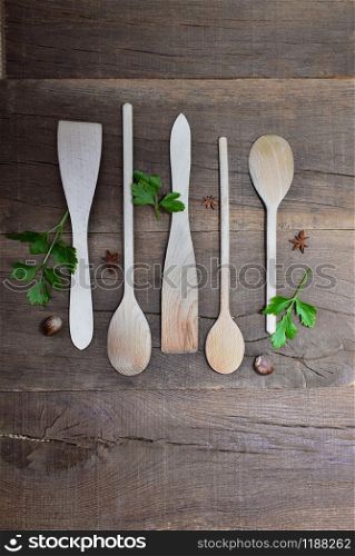 top view on arrangement of wooden kitchen utensils on a rustic plank