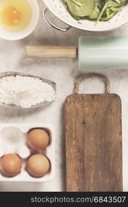 Top view on cooking ingredients and vintage kitchen accessories on old marble table