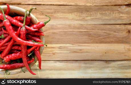 top view on red hot chili peppers on wooden background