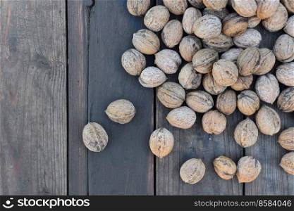 top view on walnuts in their shell spread on a plank  
