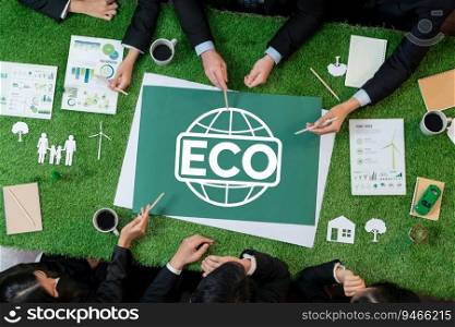 Top view panoramic ECO symbol on green grass table with business people planning for alternative energy utilization for greener sustainable Earth as corporate social responsibility. Quaint. Top view panoramic ECO symbol on grass table with business people. Quaint