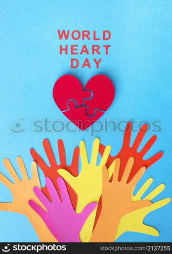 top view paper hands with puzzle paper heart