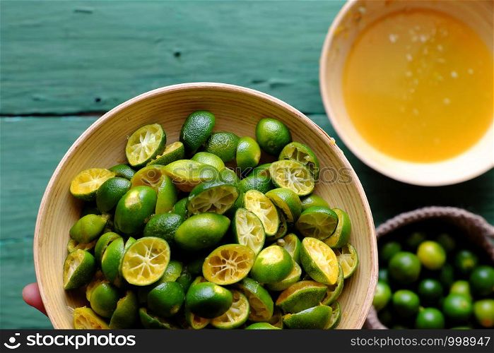 Top view people hand hold kumquat peel in green that squeezed out of fruits, this sour fruit rich vitamin c, healthy and make detox drink