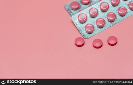 Top view pink tablets pill on pink background. Health care web banner. Vitamins and supplements for women. Pharmaceutical industry. Breast cancer or woman health topics. World health day concept.