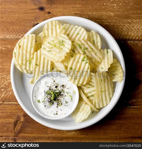 top view potato chips plate with sauce