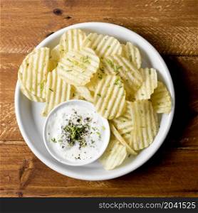 top view potato chips plate with sauce