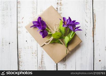 top view purple flowers tied with gift box white wooden backdrop
