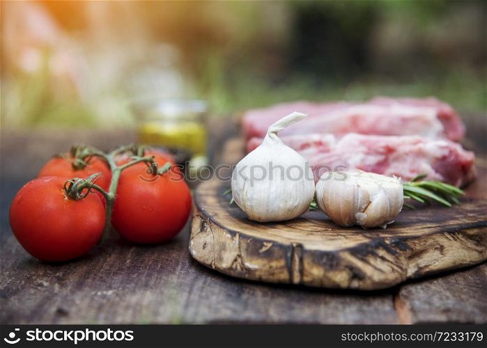 Top view raw beef meat steak ingredient uncooked cuisine on wooden board. Steak western cuisine ingredient fresh meat, pepper, olive oil, garlic, chilli, tomato, salt and rosemary outdoor for party. Western food concept