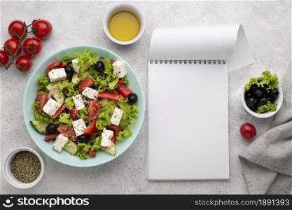 top view salad with feta cheese tomatoes and olives with blank notepad. Resolution and high quality beautiful photo. top view salad with feta cheese tomatoes and olives with blank notepad. High quality and resolution beautiful photo concept