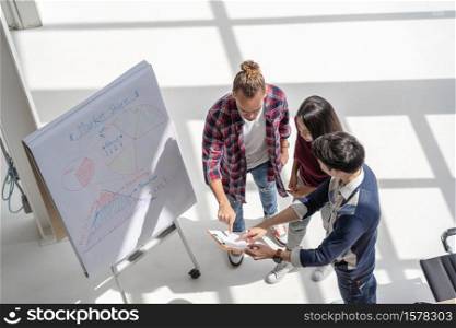 Top view scene of Asian and Multiethnic Business people with casual suit working with brainstorming and pointing to the design concept in the modern workplace, people business group concept
