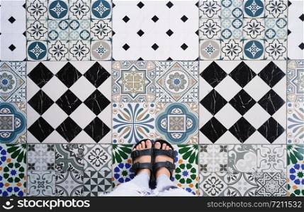 Top view selfie of feet in sandals shoes on the various vintage seamless floor background with copy space, fashion lifestyle