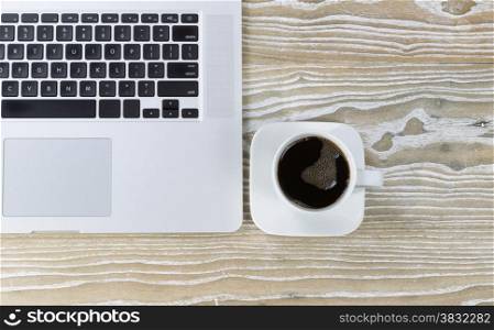 Top view shot of an old white desktop with laptop and black coffee. Layout in horizontal format.