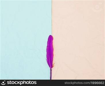 top view single pink feather against turquoise beige background