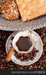 top view small cup of coffee and roasted coffee beans with cinnamon, biscuit