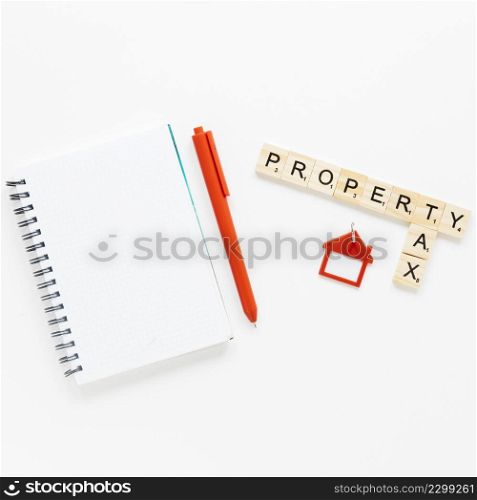 top view spiral diary near wooden blocks with property tax text isolated white background
