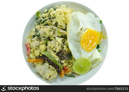 top view stir fried instant noodles with pork , chili , vegetable , slices lime and fried egg on dish over white background