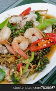 top view stir fried prawn and squid with mix vegetable on dish , spicy dish. seafood dish