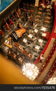 Top view to orchestra pit without musicians in the interior of the Vienna State Opera before starting performance in Vienna, Austria.. Orchestra pit without artists in the interior of the Vienna State Opera auditorium.