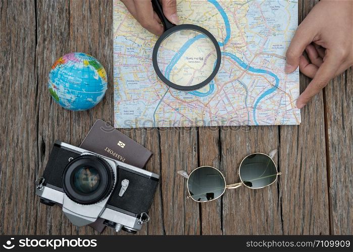 top view travel concept with retro camera films, glasses and othet items on wooden background.