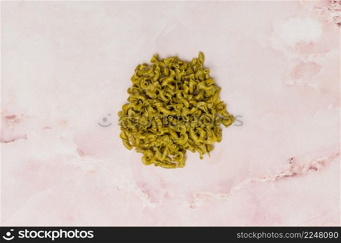 top view uncooked green italian pasta pink marble background
