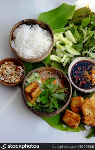 Top view vegan food ready to eat on leaf background, fried tofu, bun, cucumber and herbal leaf as mint, lettuce with soy sauce, healthy eating with vegetable make for good natural immunity