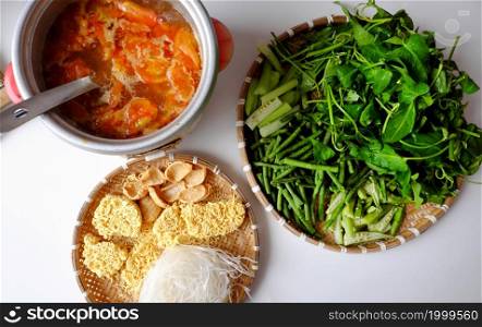 Top view Vietnamese vegan food, green vegetables hot pot homemade from tomato, soy protein, chili sate, amaranth, pepper elder, bun, spinach, healthy eating that rich fiber, vitamin for vegetarian