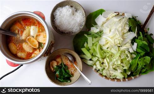 Top view Vietnamese vegan food, green vegetables hot pot homemade from tomato, soy protein, chili sate, leaf mustard, cabbage, bun, spinach, healthy eating that rich fiber, vitamin for vegetarian