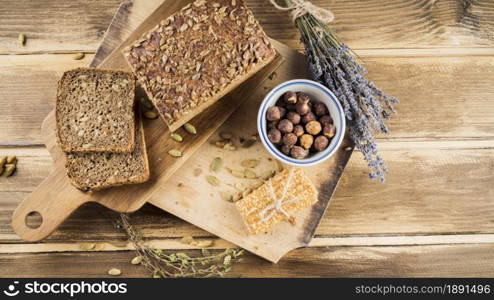 top view whole grain bread hazelnut bowl with protein bar chopping board. Resolution and high quality beautiful photo. top view whole grain bread hazelnut bowl with protein bar chopping board. High quality and resolution beautiful photo concept