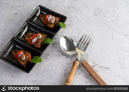 Top view with Appetizers with the spicy sardine in ceramic tray, spoon and fork placed nearly, copy space