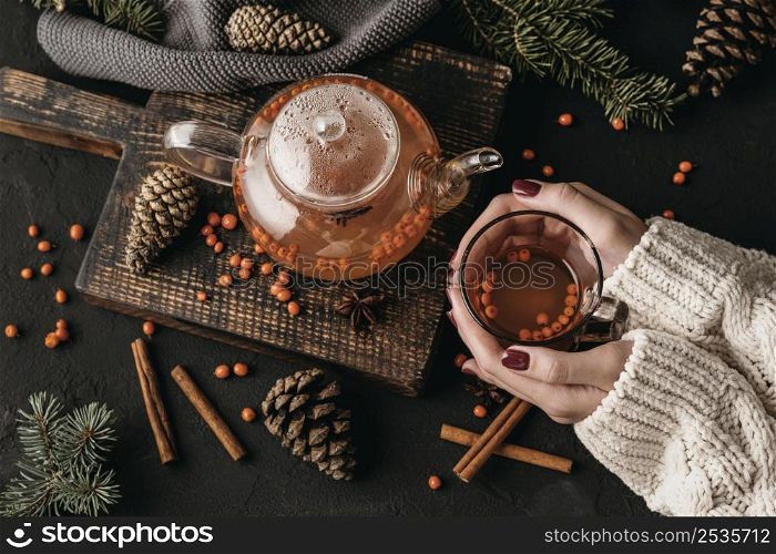 top view woman holding glsss with sea buckthorn tea