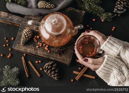 top view woman holding glsss with sea buckthorn tea